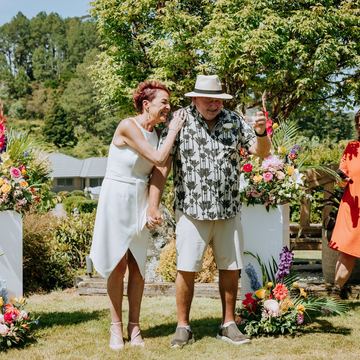 The bride and groom share a laugh during their garden ceremony