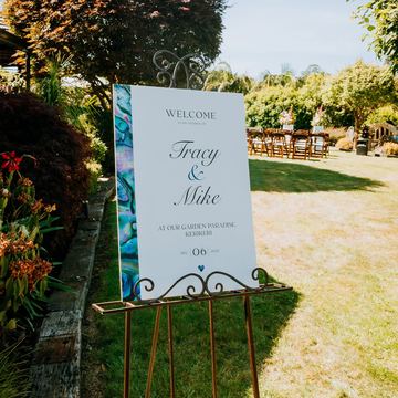 A welcome sign for Tracy and Mike's wedding on an easel in the garden