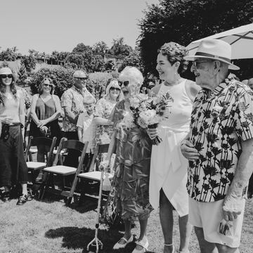 Black-and-white photo of guests gathered around the couple after the ceremony