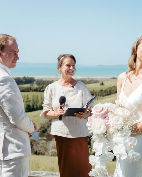 Tracy smiles as she speaks into a microphone during the ceremony