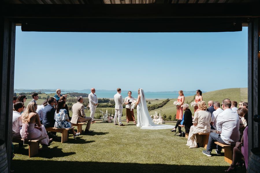 The ceremony framed by a covered deck, with guests on either side of the aisle
